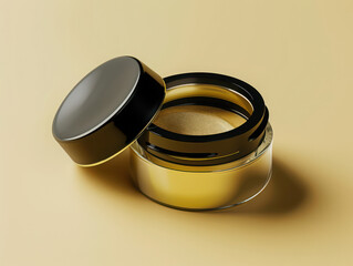 Closeup of a small open container of shimmering gold powder with a black lid on a tan background