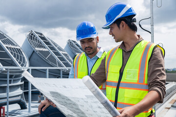 Engineers discussing building plans on rooftop site