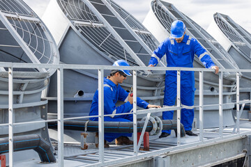 Engineers performing maintenance on rooftop ventilation system