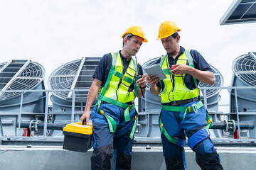 Construction workers coordinating rooftop solar installation