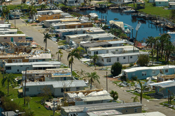 Fototapeta premium Aerial view of badly damaged mobile homes after hurricane Ian swept through residential area in Florida. Aftermath of natural disaster