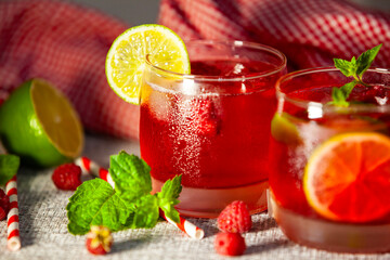 Fruit mocktail with fresh garnish, striped straw and natural linen background. Summer fruit drink in rustic styling.