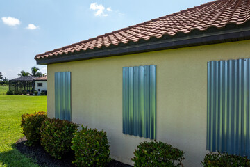 Boarded windows with storm shutters for hurricane protection of Florida home. Protective measures...