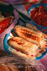 A vibrant outdoor barbecue scene with people grilling shashlik and marinated vegetables over an open fire. Juicy skewered meat and colorful vegetables sizzle on the mangal, surrounded by friends enjoy