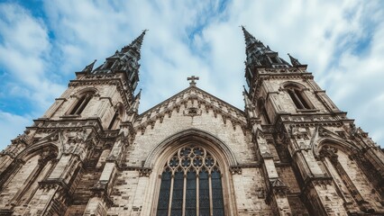 Fototapeta premium Historic stone church featuring Gothic and Baroque architectural elements with tower spires