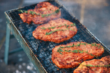 A vibrant outdoor barbecue scene with people grilling shashlik and marinated vegetables over an open fire. Juicy skewered meat and colorful vegetables sizzle on the mangal, surrounded by friends enjoy