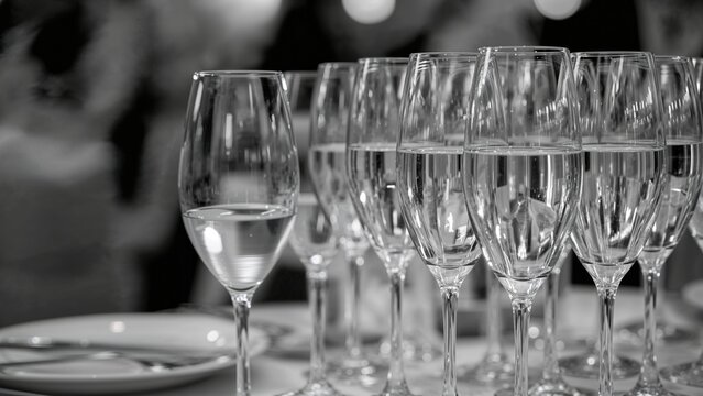 Monochrome close-up of sparkling wine glasses arranged for a party event - Powered by Adobe