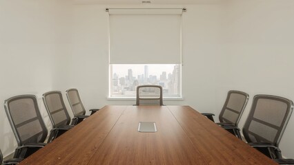 Deserted meeting space with an expansive wooden table and rear roller blinds.