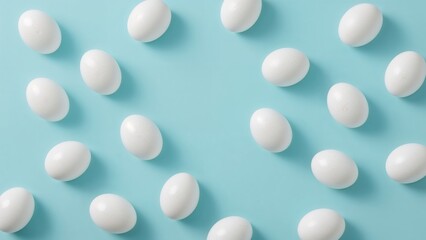 Creative Easter holiday backdrop featuring white eggs and space for text on a blue surface.