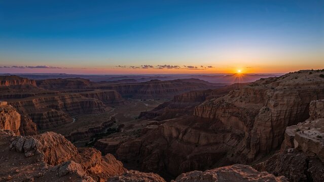 Sunrise panorama of a vast erosion crater in a desert landscape