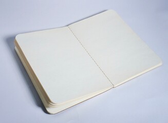 Opened empty book with white plain paper isolated on horizontal copy spaced white background.