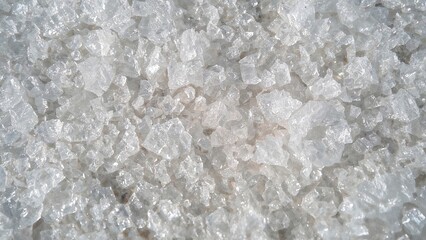 Close-up imagery of frost crystals on ground, white ice pattern, seasonal cold surface