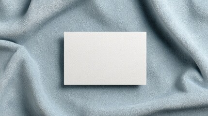 Blank White Card On Textured Blue Fabric Background. Ideal For Branding, Invitations, Or Announcements