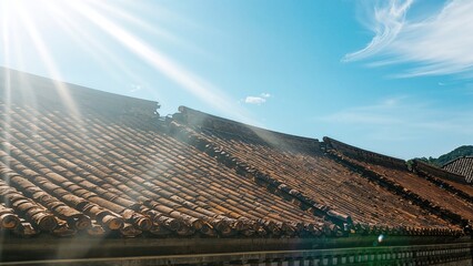 Illumination falls upon neighboring rooftops covered with tiles.