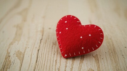 Felt heart ornament accompanied by white stars set against a wooden texture with space for writing