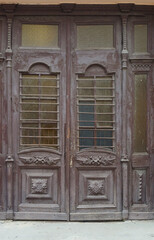 Antique Wooden Double Doors with Ornate Carvings and Glass Panels