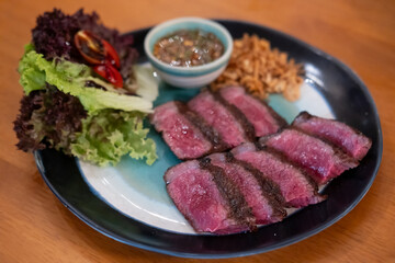 Medium rare sliced Picanha steak meat served on plate with vegetable