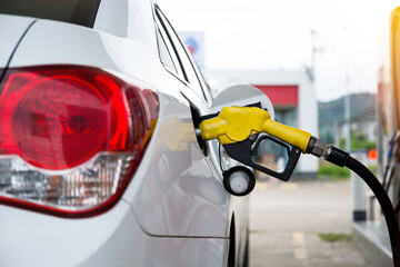 Closeup fuel dispenser gasoline fuel in car at gas station. Petrol or gasoline being pumped into a motor vehicle car.Price expensive during war.
