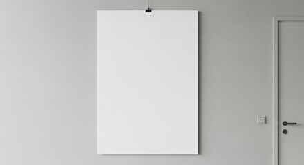 A blank canvas hanging on a wall in a minimalist room.