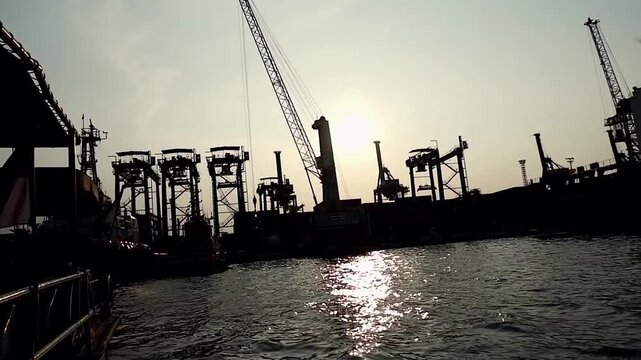 Container ships loading and discharging by shore crane in International Port of Tanjung Priok. Logistics and transportation of shipping, steve doring and lift on lift off at container yard. Jetty view