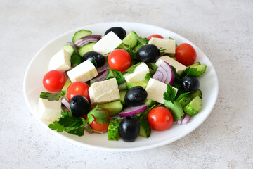 Fresh and Colorful Greek Salad on a White Plate isolated close up