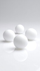 Four white spheres on a white surface