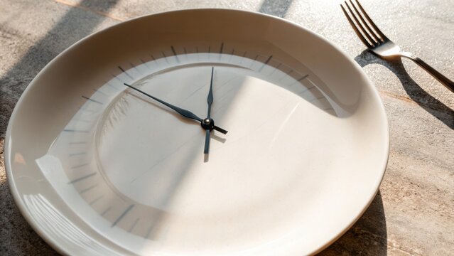 Intermittent Fasting Success Concept. A plate resembling a clock reflects the concept of time and dining.