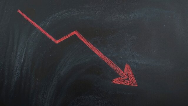 Red arrow drawn with chalk on blackboard illustrating a downward trend in economy