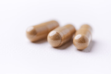 Ashwagandha (Withania somnifera) capsules. Concept for a healthy dietary supplementation. Bright paper background. Close up. Copy space.	