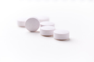 Creatine tablets on paper background. Soft focus. Close up. Copy space.	