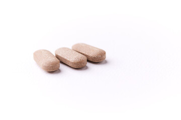Ashwagandha (Withania somnifera) tablets on paper background. Soft focus. Close up. Copy space.	