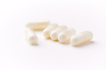 Creatine capsules on paper background. Soft focus. Close up. Copy space.	