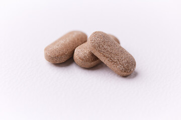 Ashwagandha (Withania somnifera) tablets on paper background. Soft focus. Close up. Copy space.	