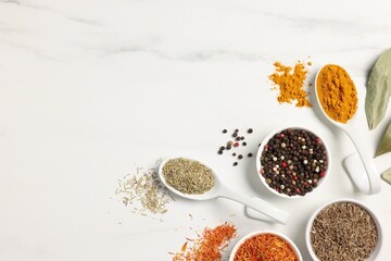 Different aromatic spices on white marble table, flat lay. Space for text