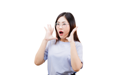 A surprised Asian young beautiful with glasses expresses shock, raising her hands to her face while widening her mouth in astonishment.