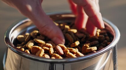Person's hand reaching into metal bowl. Hand picking nuts from a jar. Closeup of a metal bowl with fingers. A hand belonging to someone extends into a metallic bowl lifestyle. - Powered by Adobe