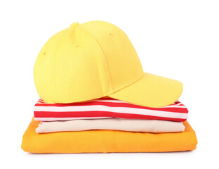 Yellow baseball cap and stack of folded t-shirts isolated on white. Mockup for design