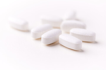 Creatine tablets on paper background. Soft focus. Close up. Copy space.	