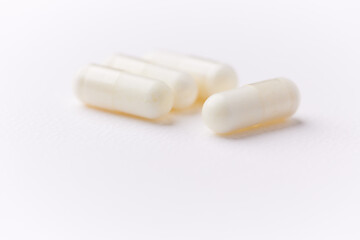 Creatine capsules on paper background. Soft focus. Close up. Copy space.	