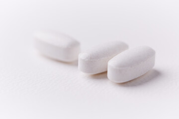 Creatine tablets on paper background. Soft focus. Close up. Copy space.	