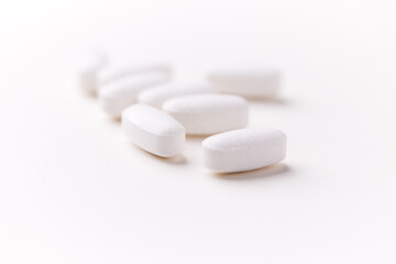 Creatine tablets on paper background. Soft focus. Close up. Copy space.	