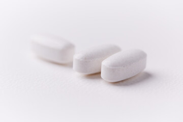 Creatine tablets on paper background. Soft focus. Close up. Copy space.