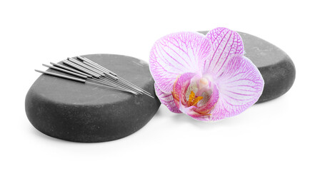 Acupuncture needles, orchid flower and spa stones isolated on white