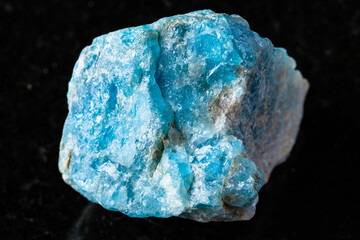sample of raw apatite mineral on black granite