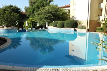 Outdoor swimming pool and green plants at luxury resort