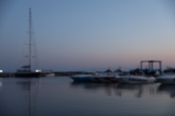 Fototapeta premium Moored boats in sea port at sunset, blurred view