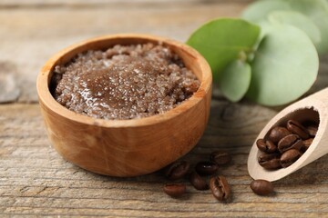 Natural body scrub and coffee beans on wooden table, closeup