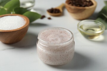 Natural body scrub and ingredients on white table, closeup