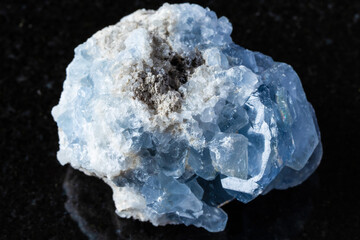 sample of raw celestite mineral on black granite
