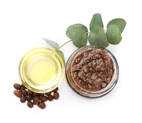 Natural body scrub in glass jar, coffee beans, oil and eucalyptus branch isolated on white, top view